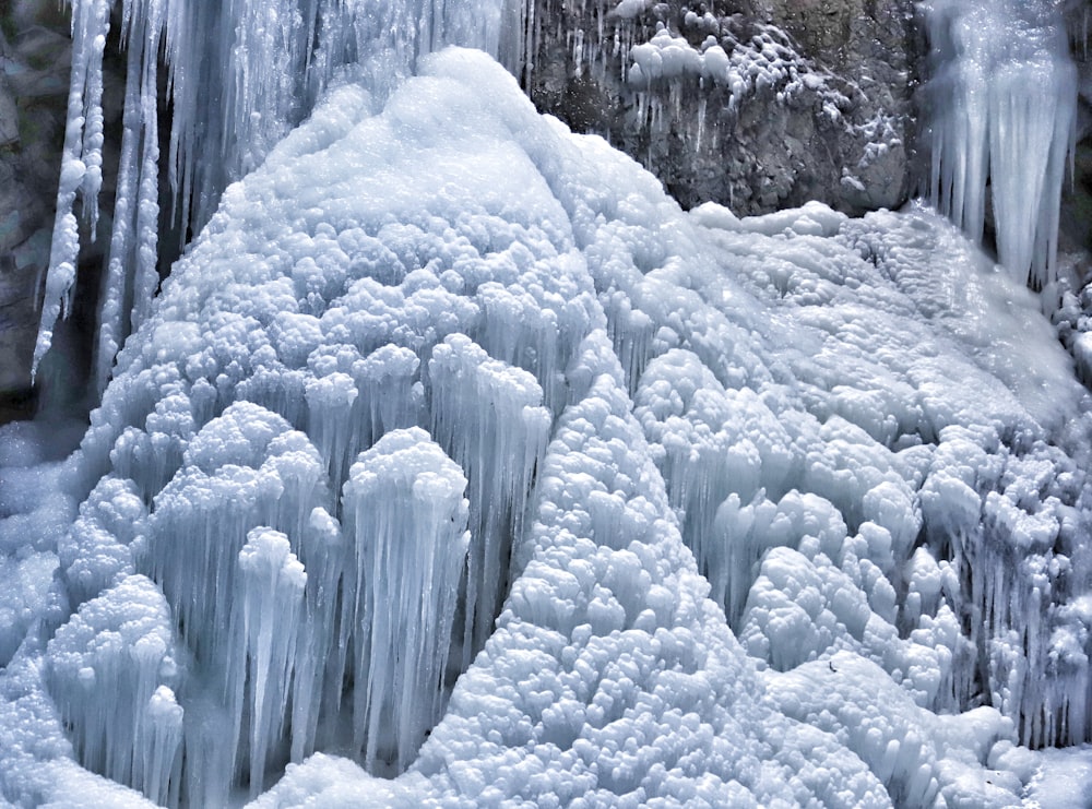 a waterfall covered in ice next to a cliff