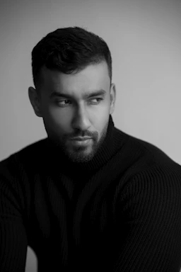a black and white photo of a man in a sweater