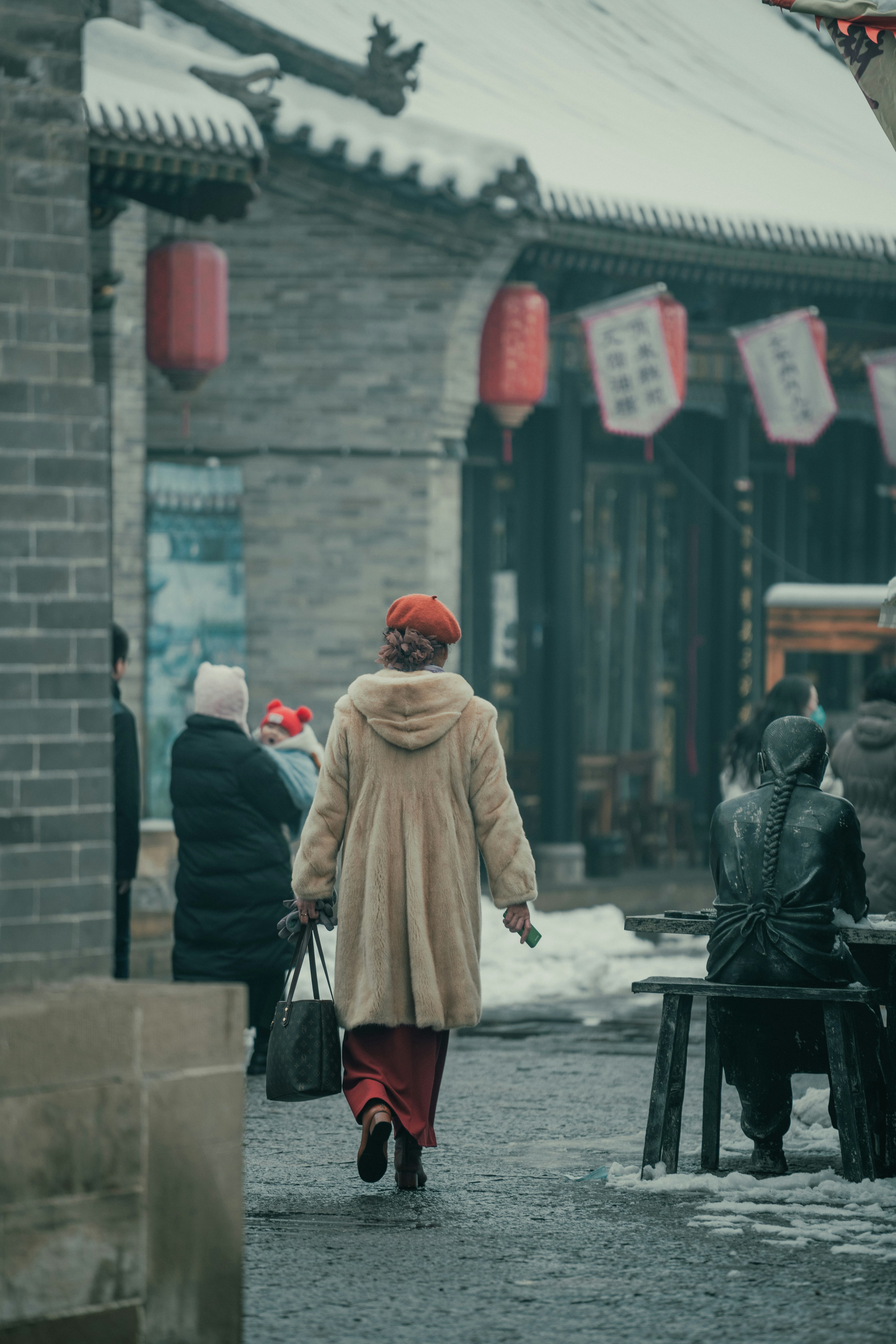 A woman in a fur coat walking down a street photo – Free China Image on ...