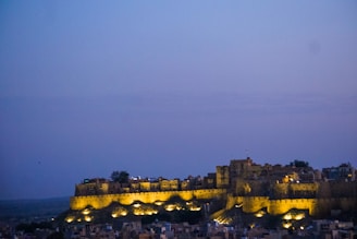 a castle lit up at night in the distance