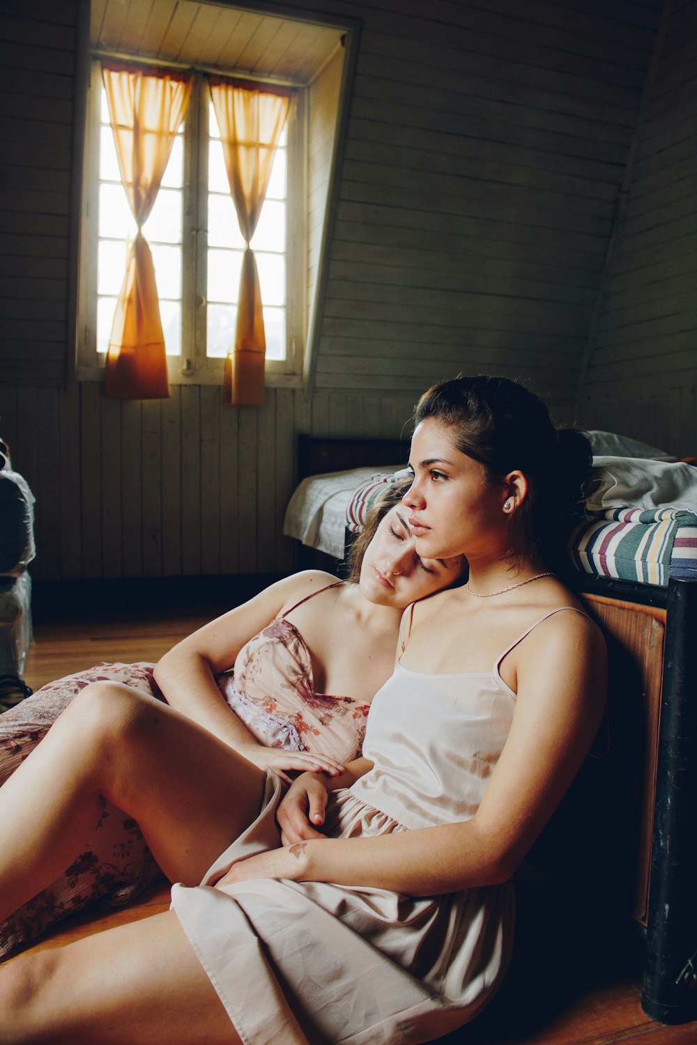 a woman sitting on a bed talking on a cell phone