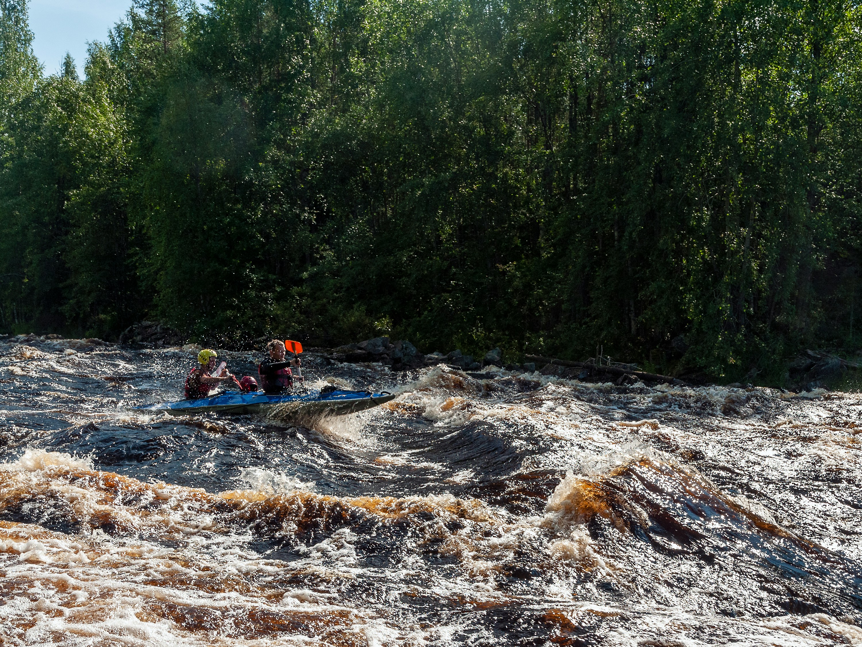 a group of people riding on top of a raft down a river