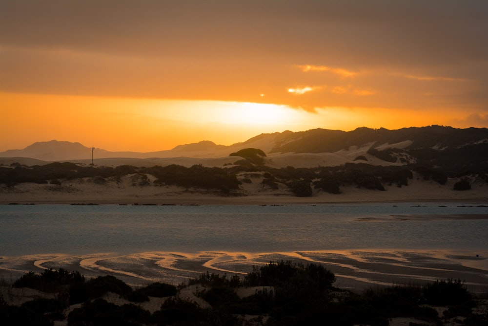 the sun is setting over a body of water