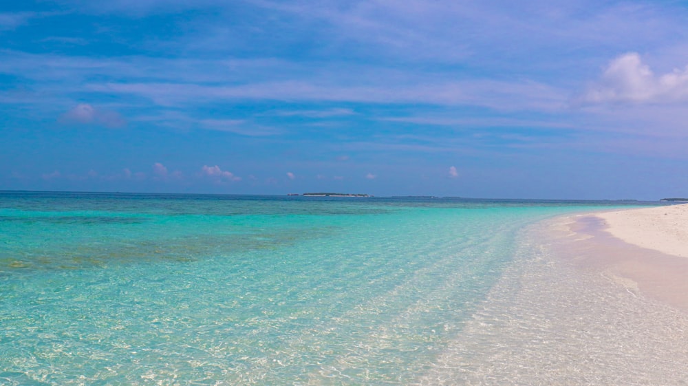 a beach with clear blue water and white sand