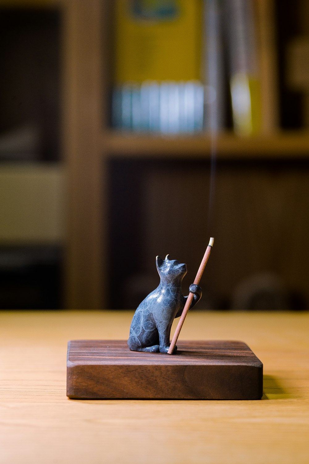 a small figurine of a cat holding a pencil