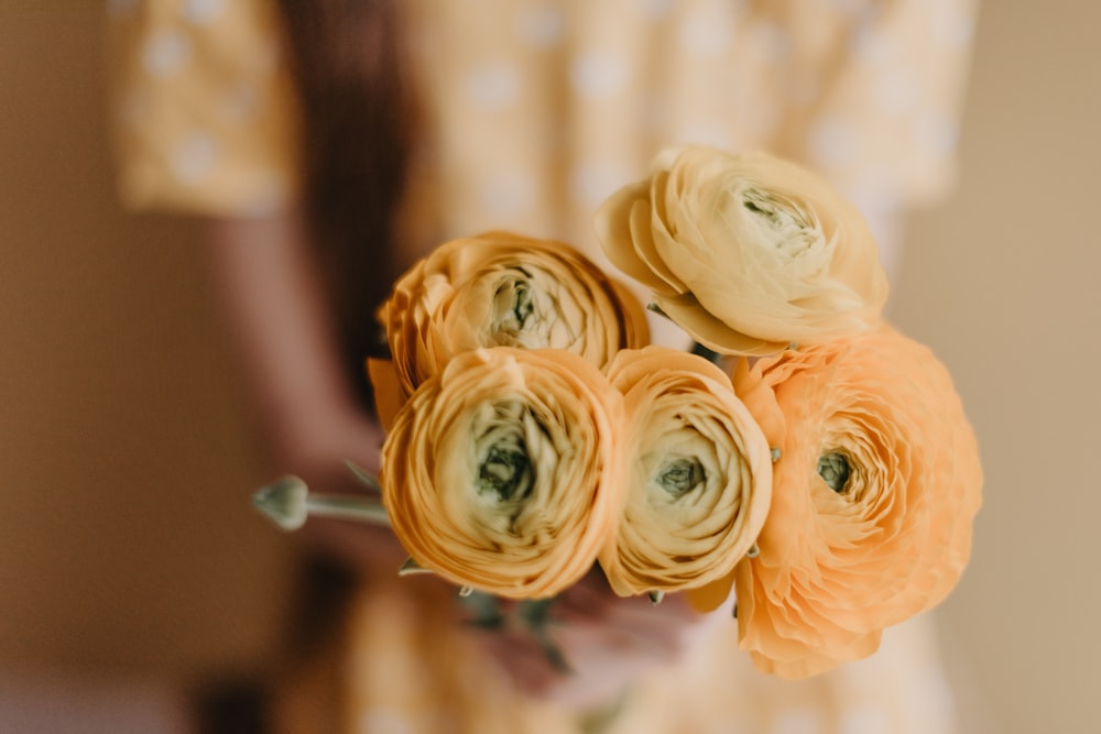 a person holding a bunch of flowers in their hand