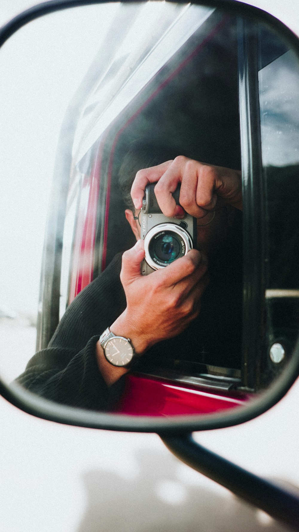 a man taking a picture of himself in a rear view mirror