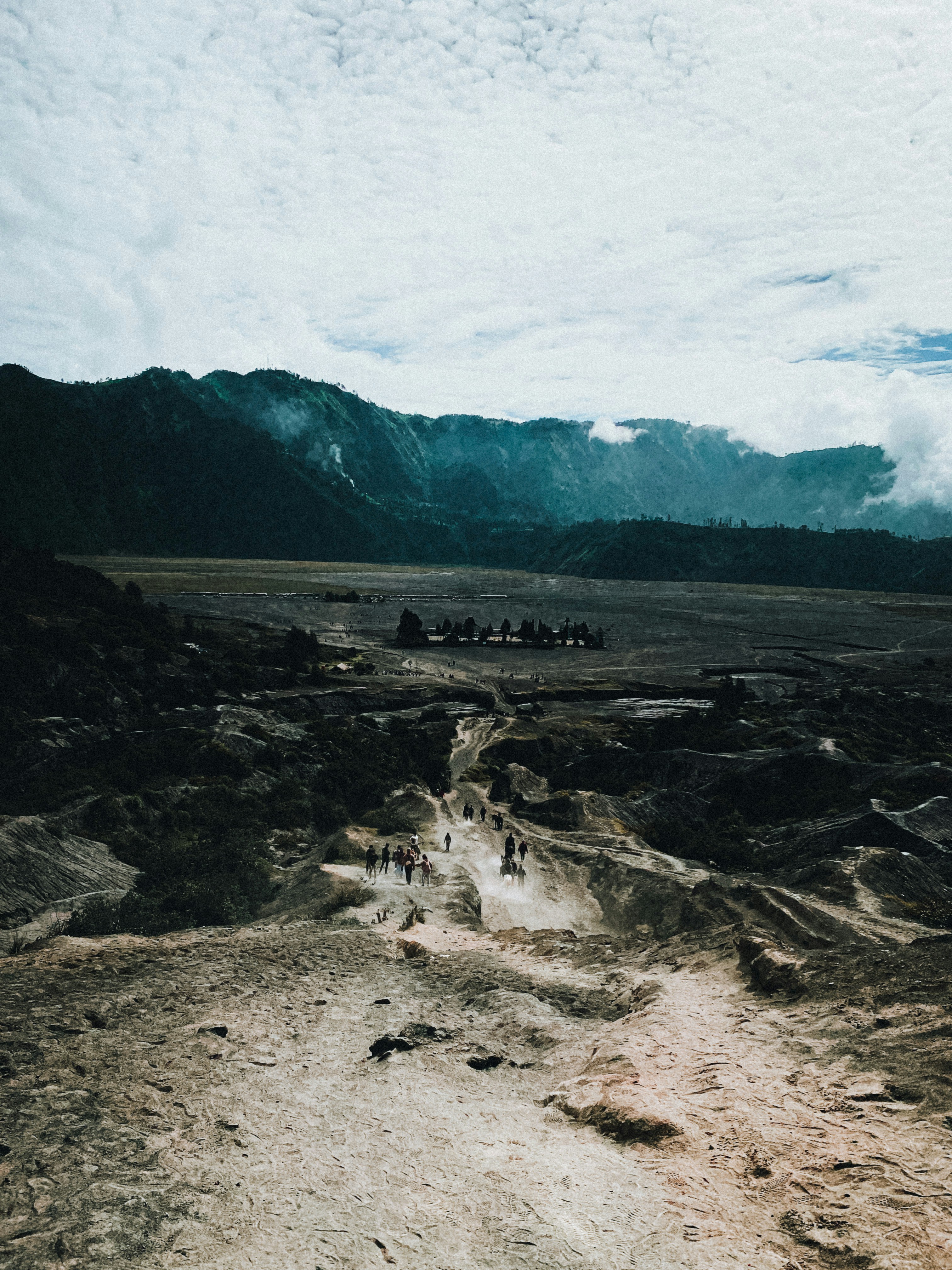 A group of people walking down a dirt road photo – Free Green Image on ...