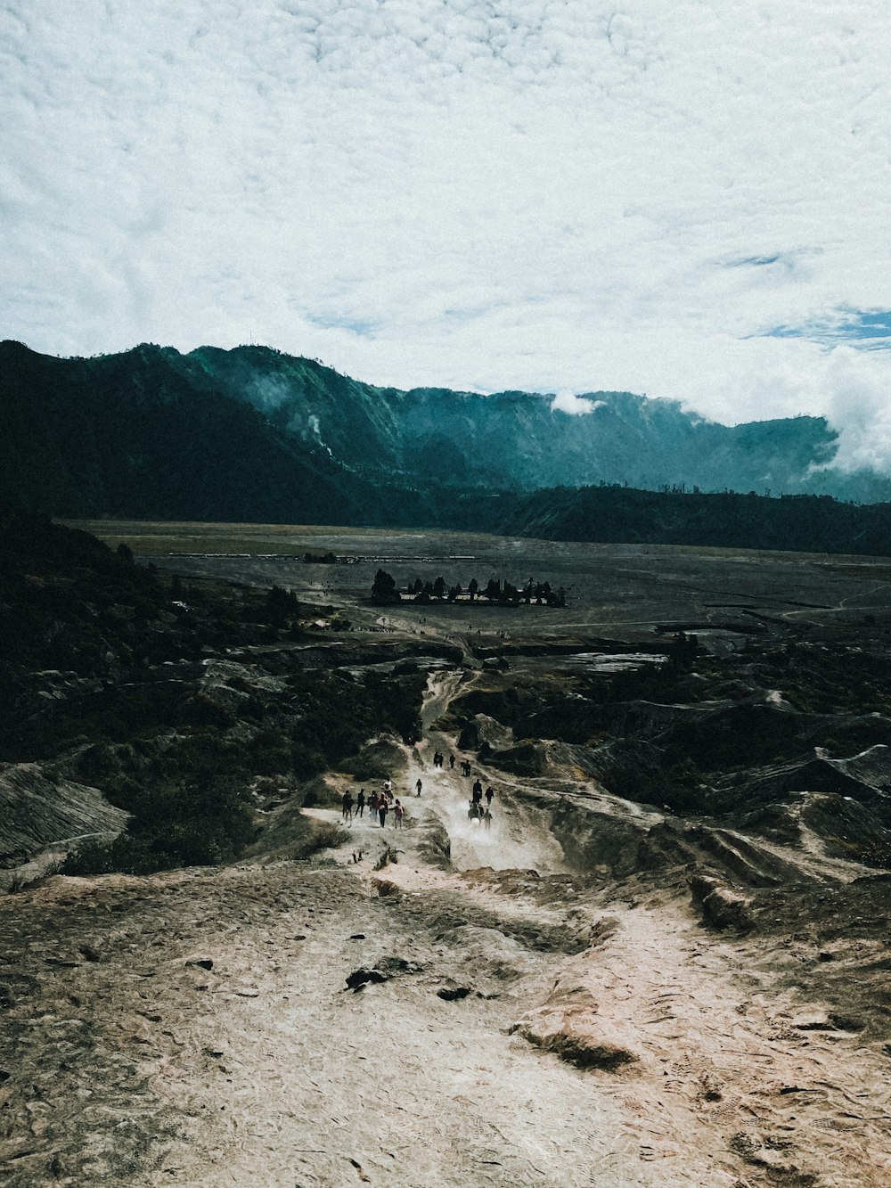 a group of people walking down a dirt road