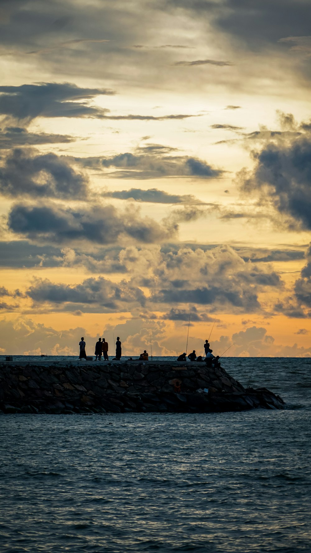 a group of people standing on top of a pier