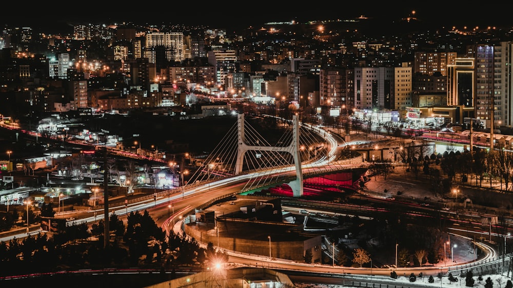 Eine Nachtansicht einer Stadt mit einer Brücke im Vordergrund