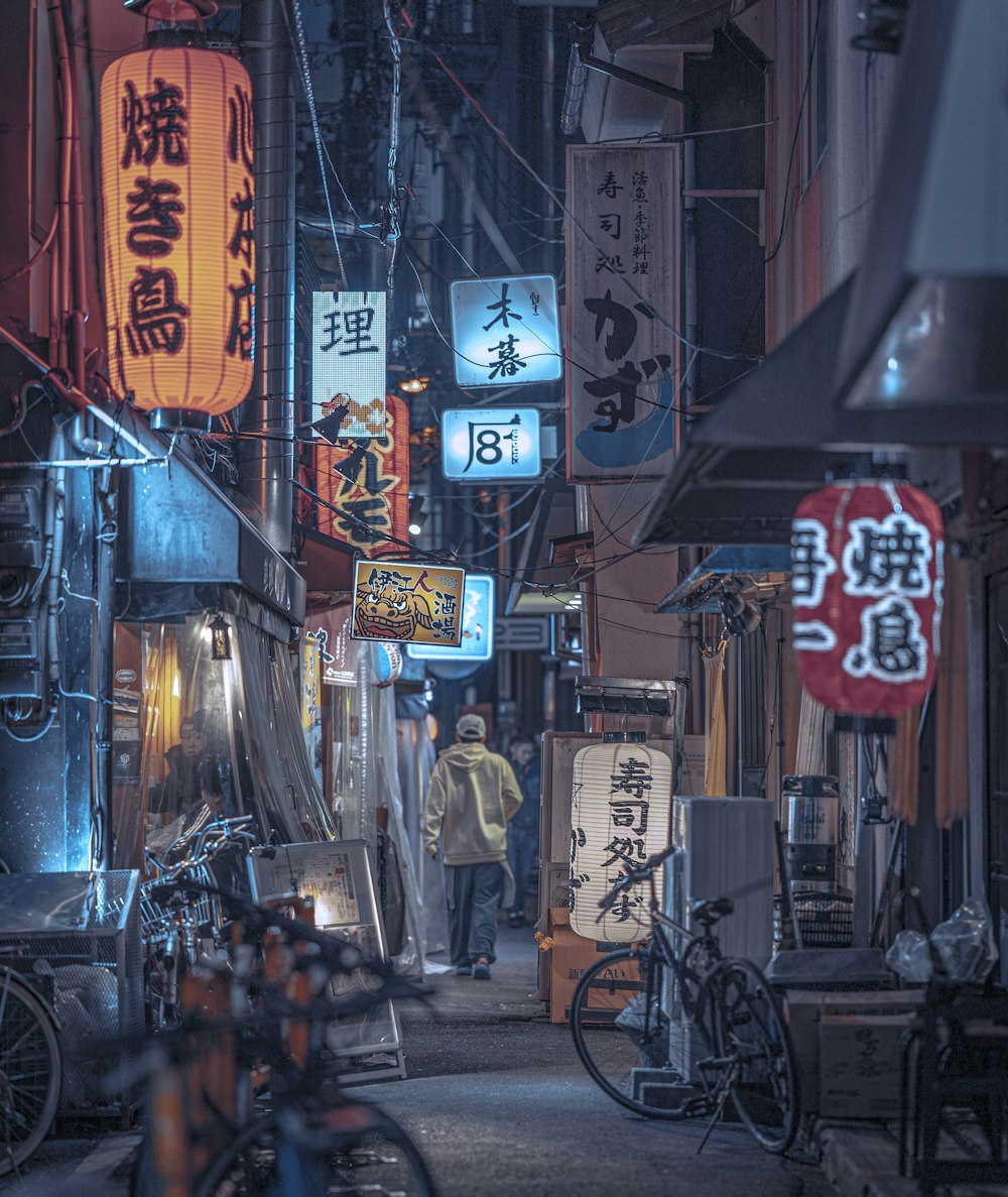 a man walking down a street next to tall buildings