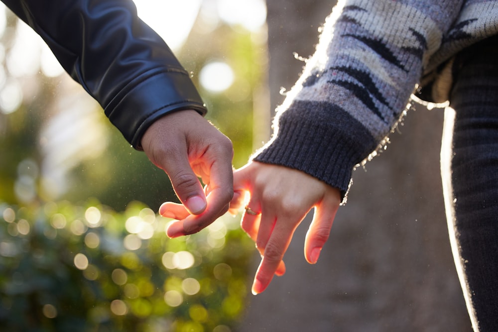 a close up of two people holding hands