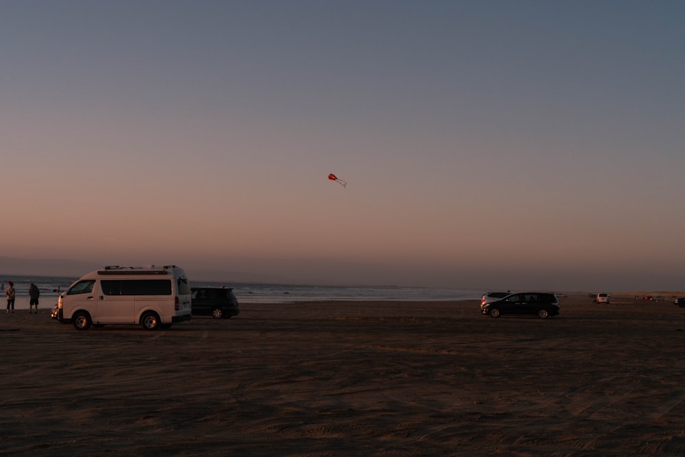 a white van parked on top of a sandy beach