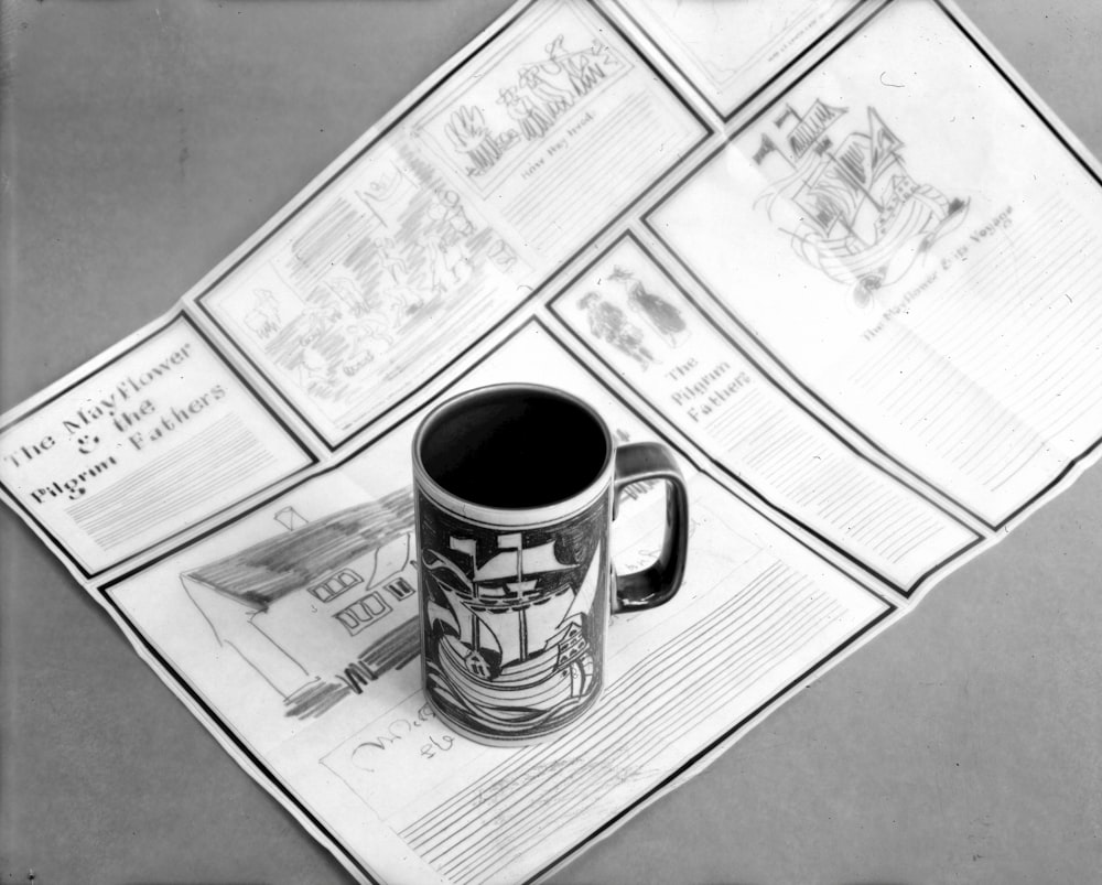 a coffee mug sitting on top of a newspaper
