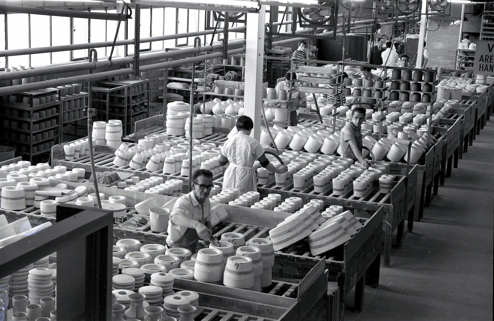 a black and white photo of workers in a factory