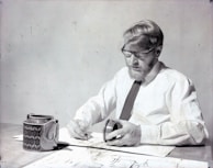 a man sitting at a table in front of a coffee mug
