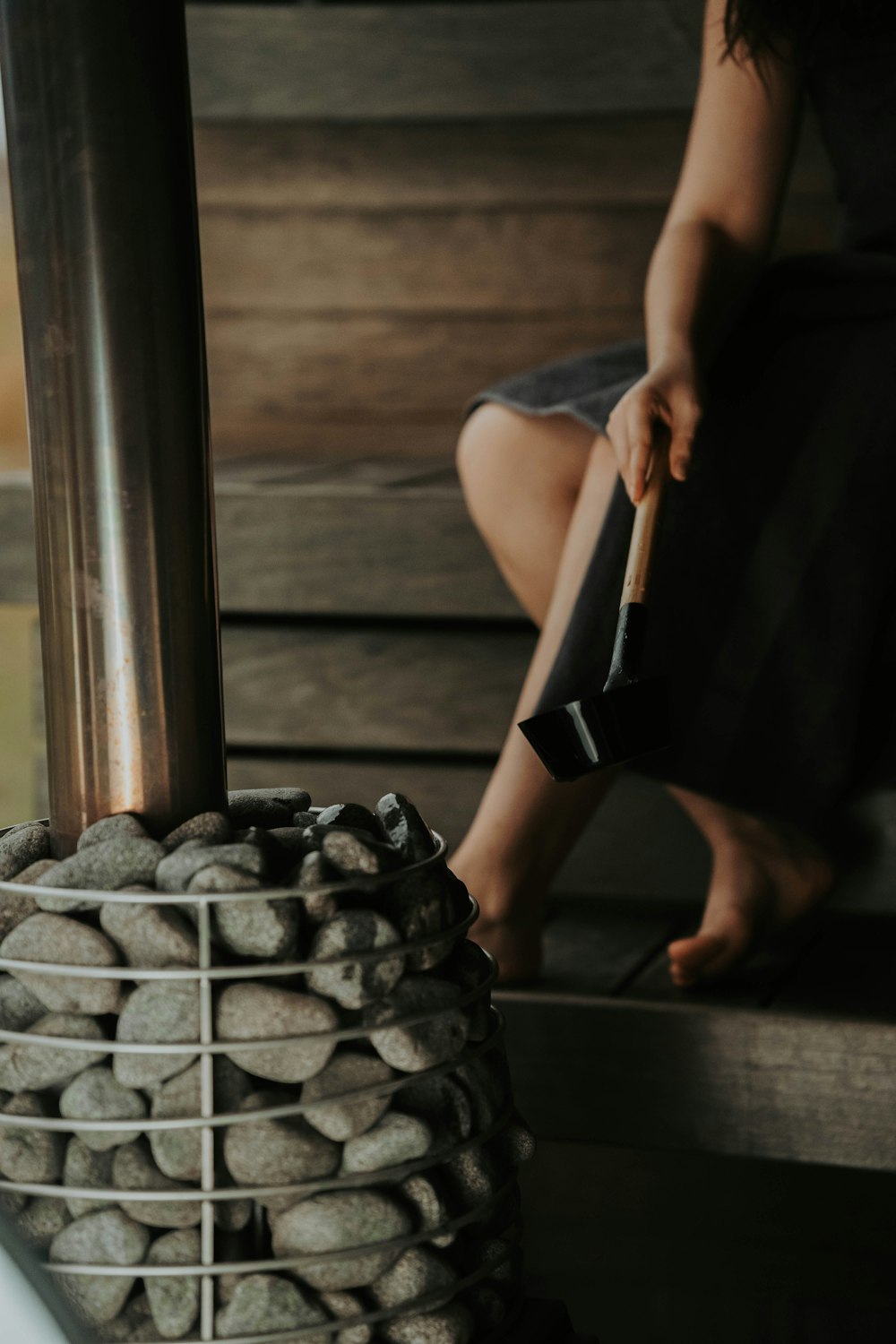 a woman sitting on a bench next to a pile of rocks