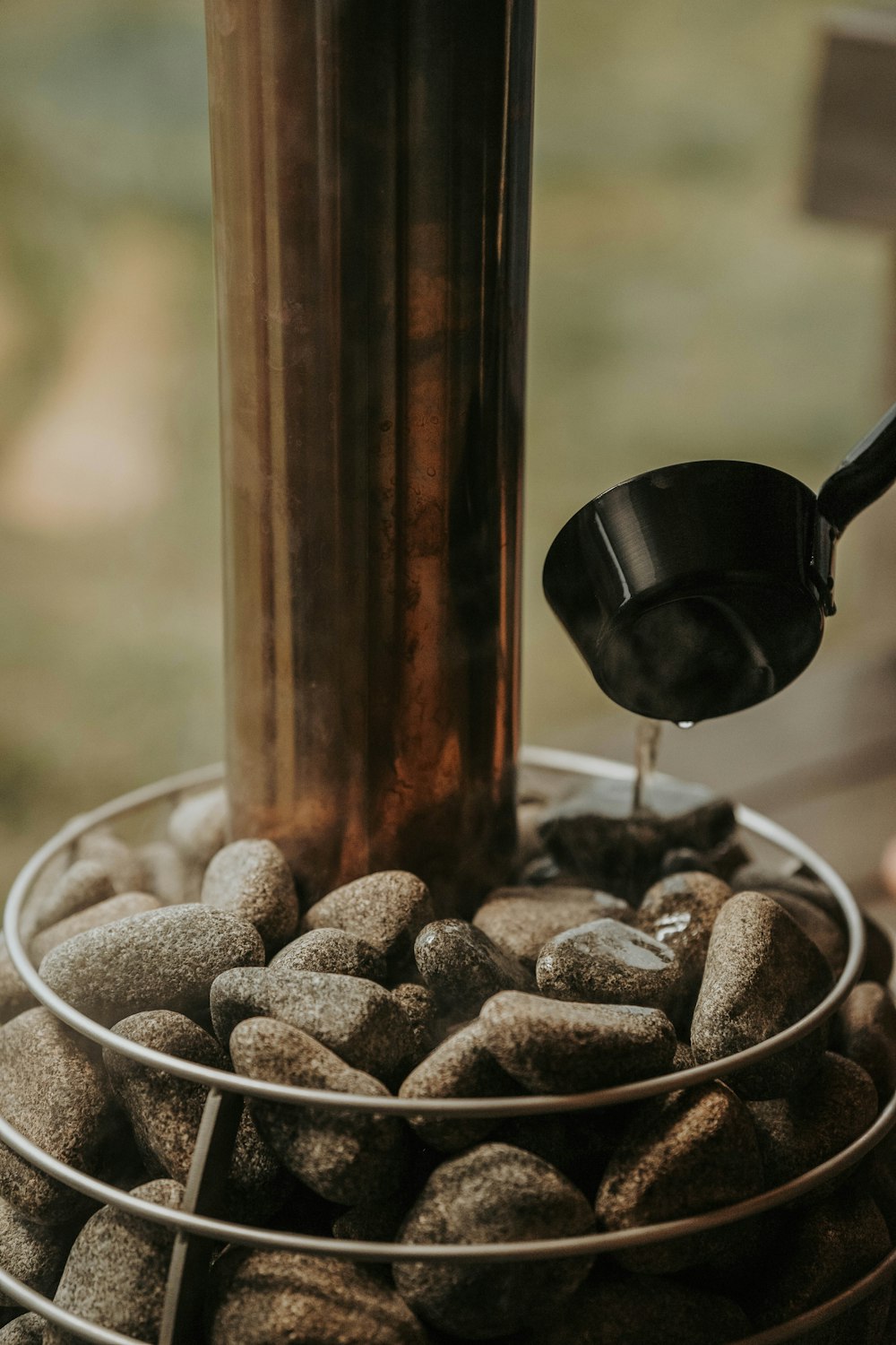 a metal container filled with rocks next to a window