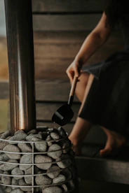 a woman is sitting on a bench with rocks and a shovel
