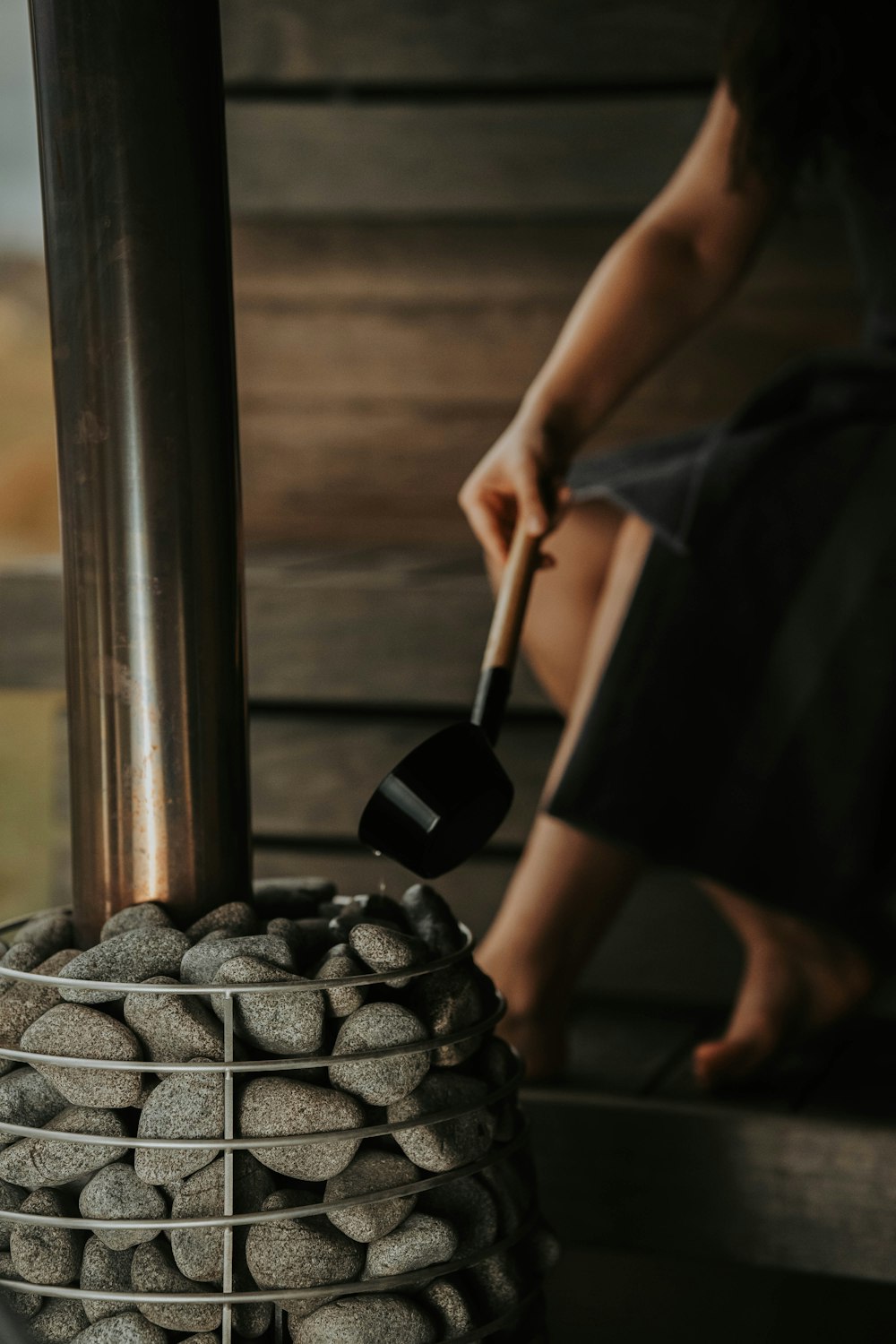 a woman is sitting on a bench with rocks and a shovel