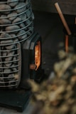 A rugged fire starter kit with flint and steel, resting on natural wood with glowing embers nearby.
