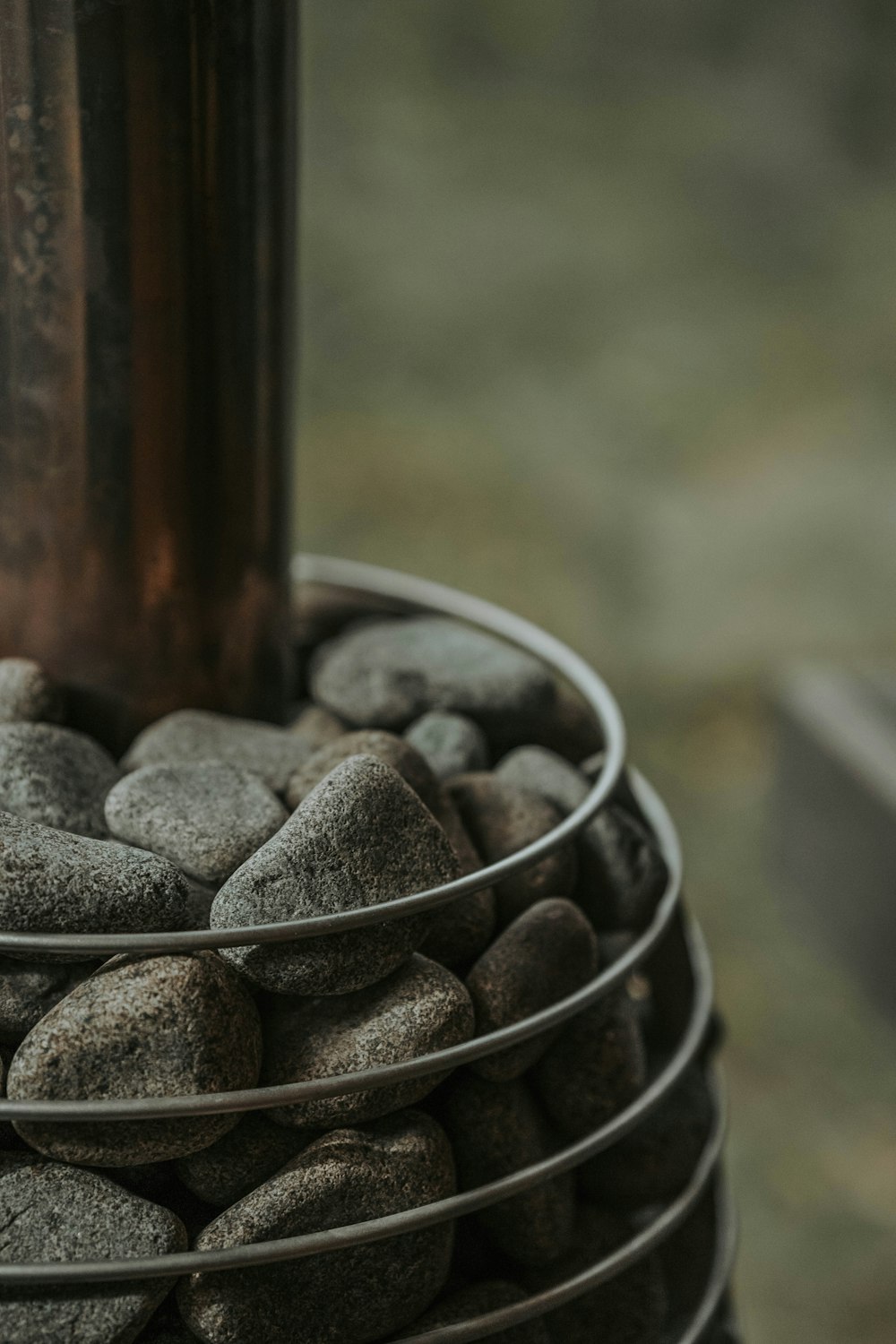 a metal container filled with rocks next to a metal pole