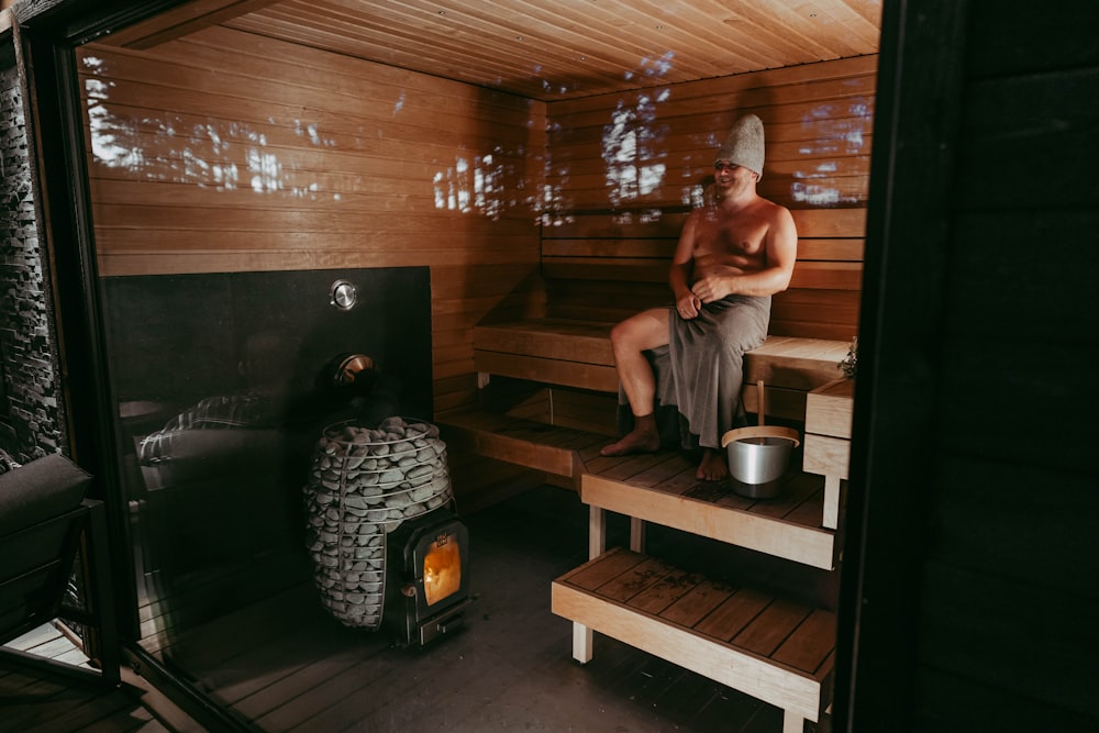 Un hombre sentado en una sauna de madera