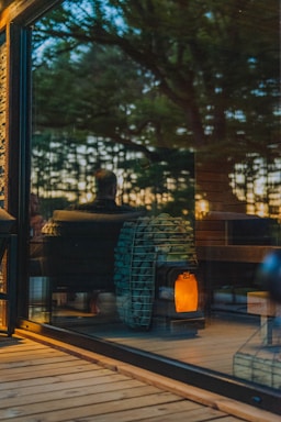 A friendly technician inspecting a biomass stove in a cozy home setting.