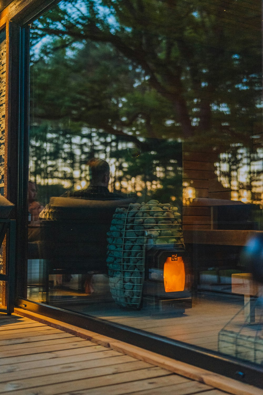 the reflection of a man sitting on a bench in a window