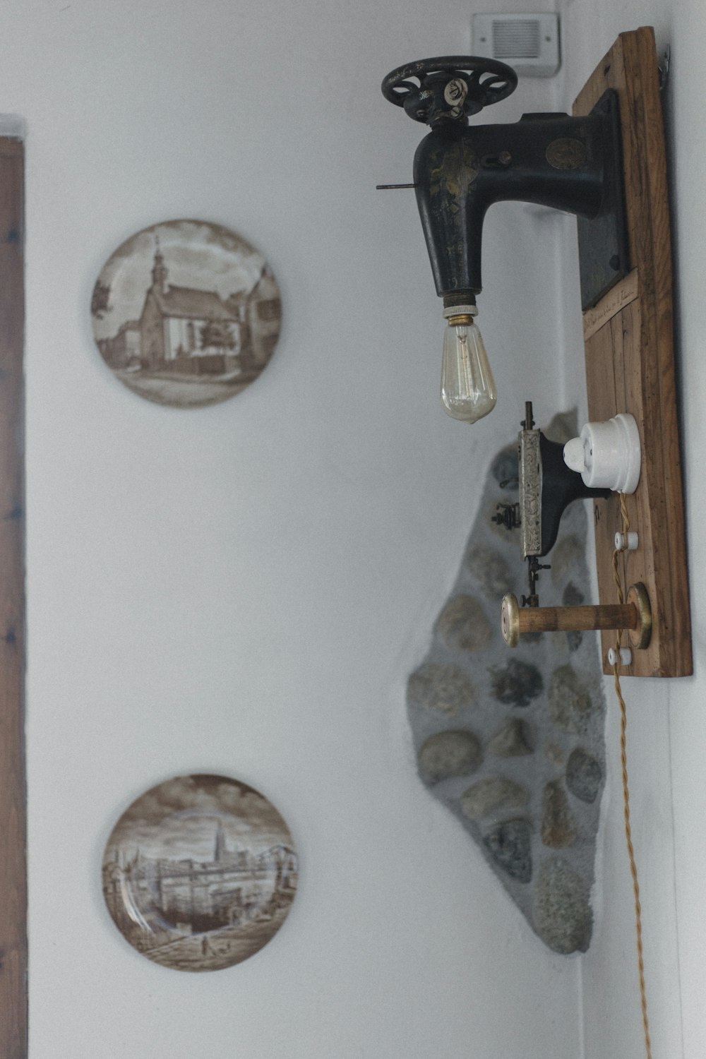 a wall with three plates and a sewing machine on it