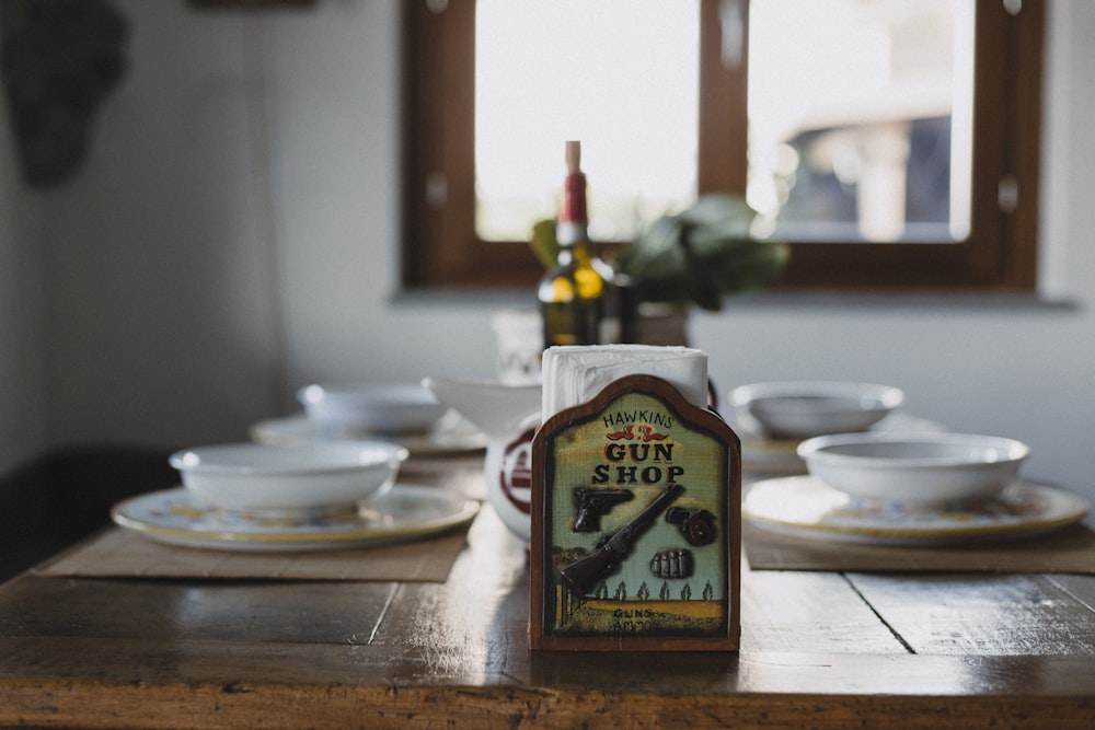 a wooden table topped with plates and a bottle of wine