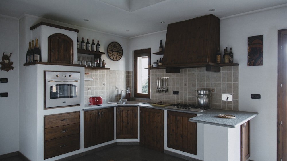 a kitchen with a stove, sink, oven and cabinets
