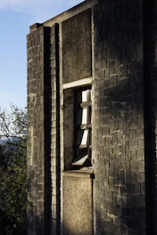 Close-up of natural clay brick cladding installed on a modern Bangalore office facade under bright sunlight.