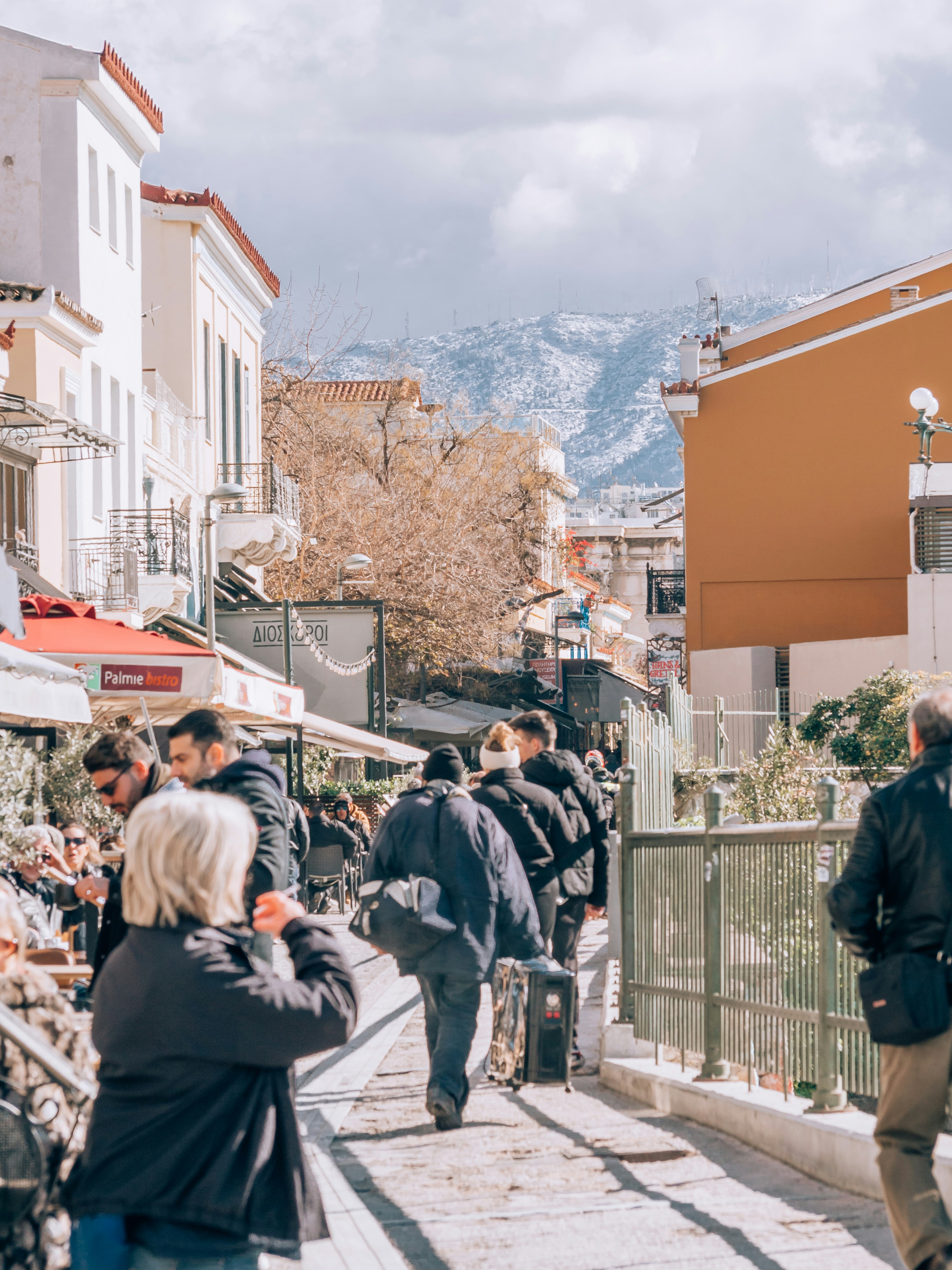 a group of people walking down a street next to buildings