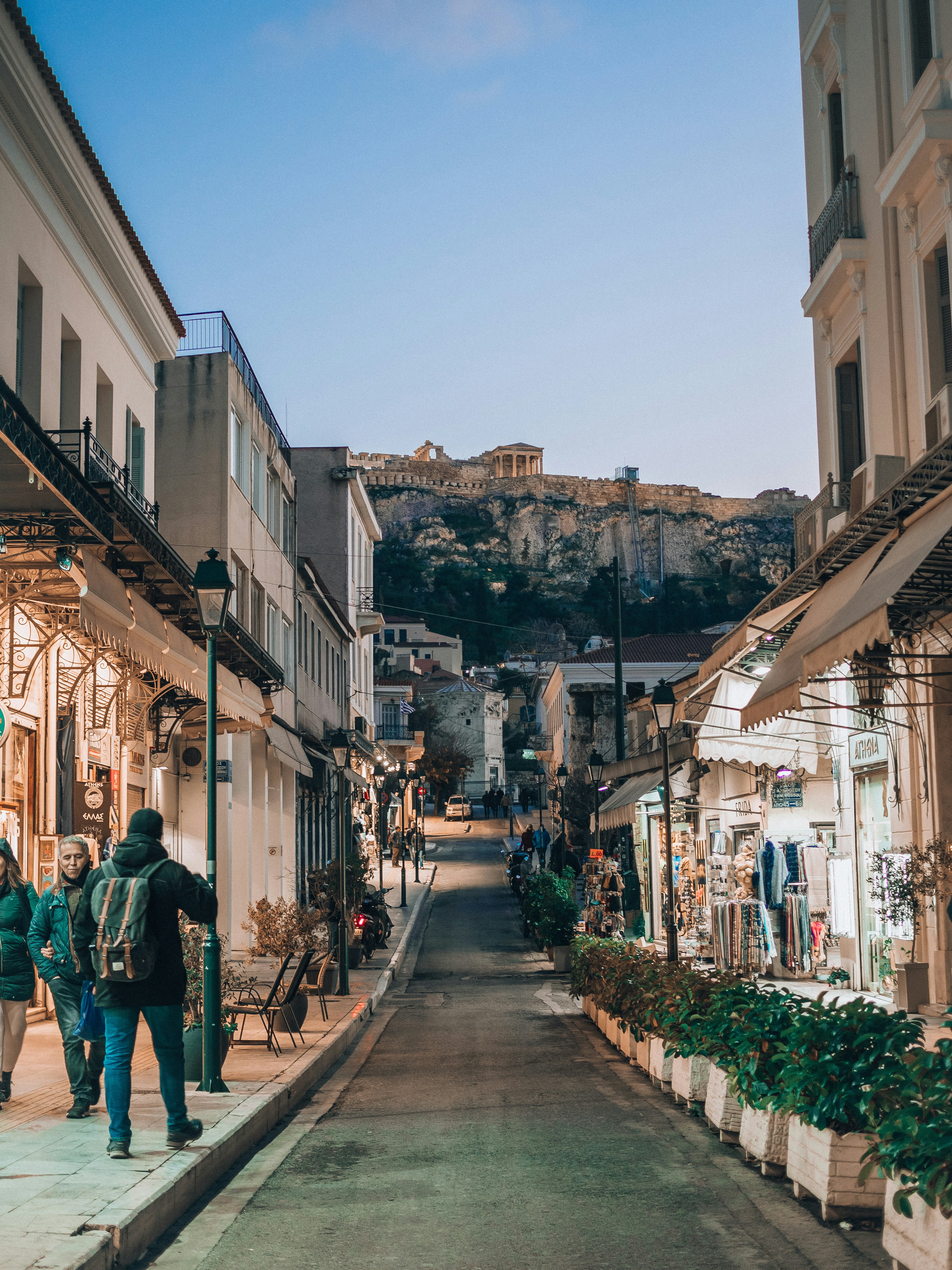 two people are walking down a narrow street