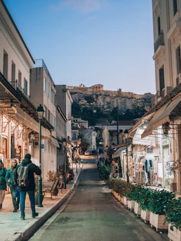 two people are walking down a narrow street