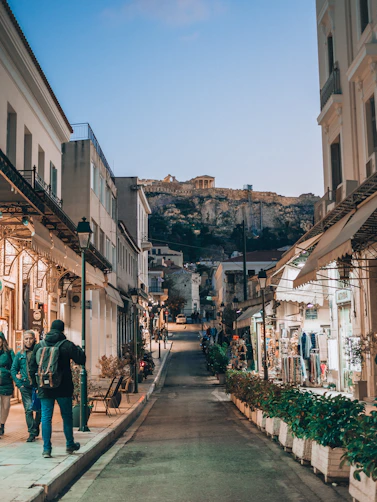 two people are walking down a narrow street