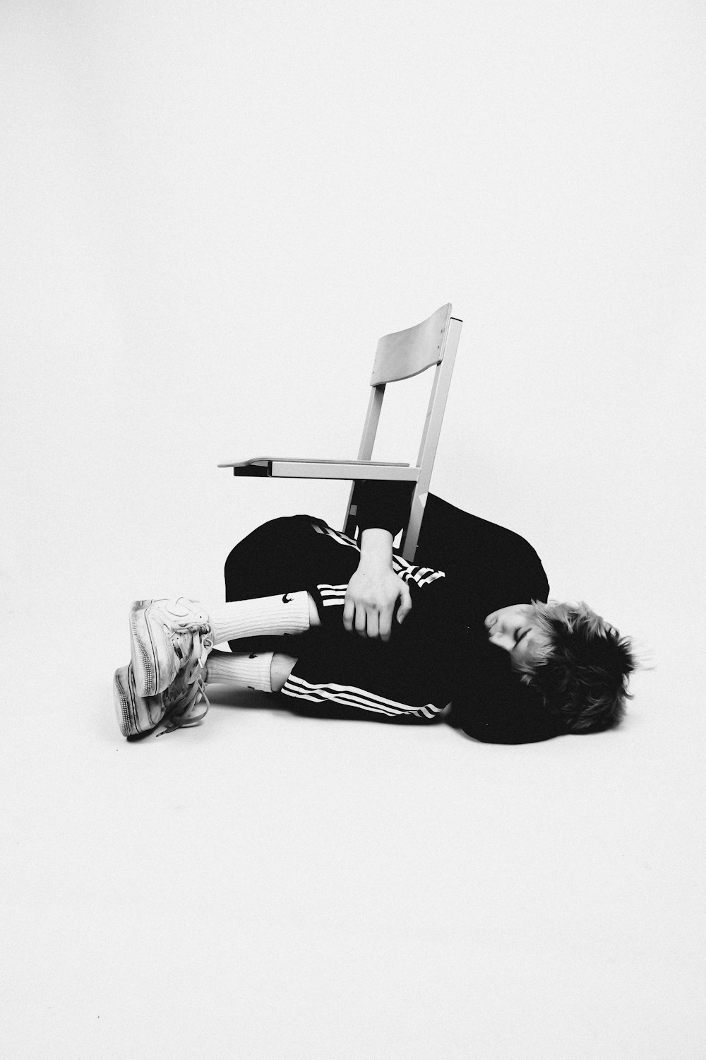a person laying on the ground next to a chair