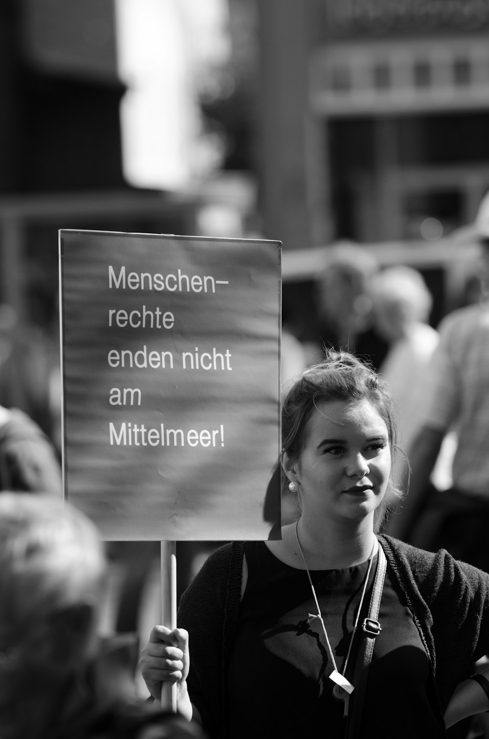 a woman holding a sign in a crowd