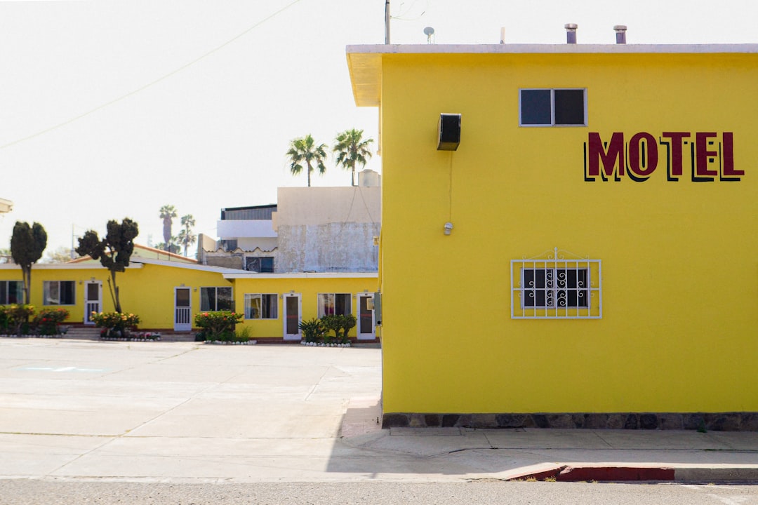 a yellow building with a motel sign on the side of it,