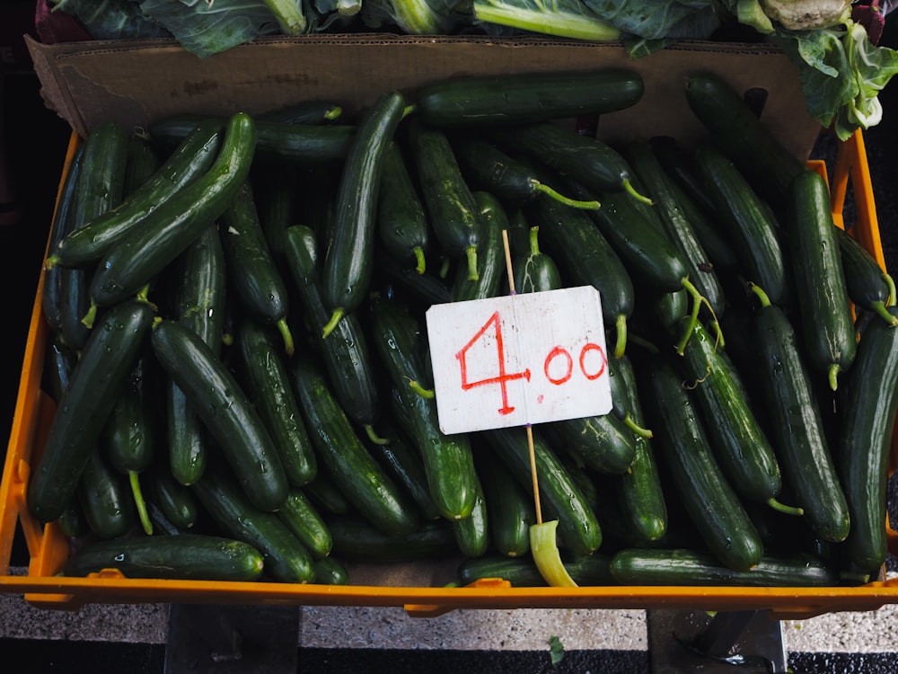 a crate of cucumbers for sale at a farmer's market