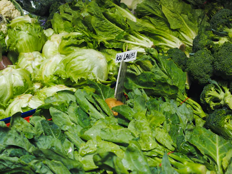 Close-up image of fresh Malaysian farm produce like leafy greens and tropical fruits neatly arranged.
