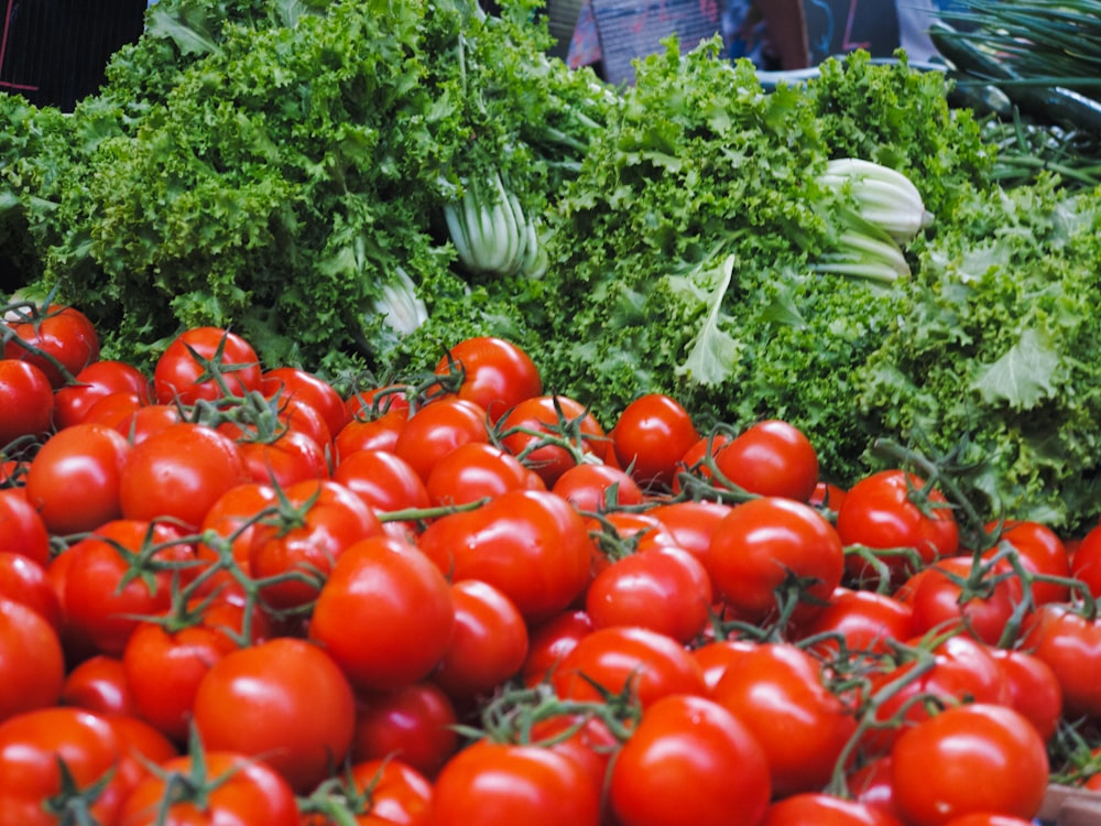 a pile of tomatoes and lettuce on a table