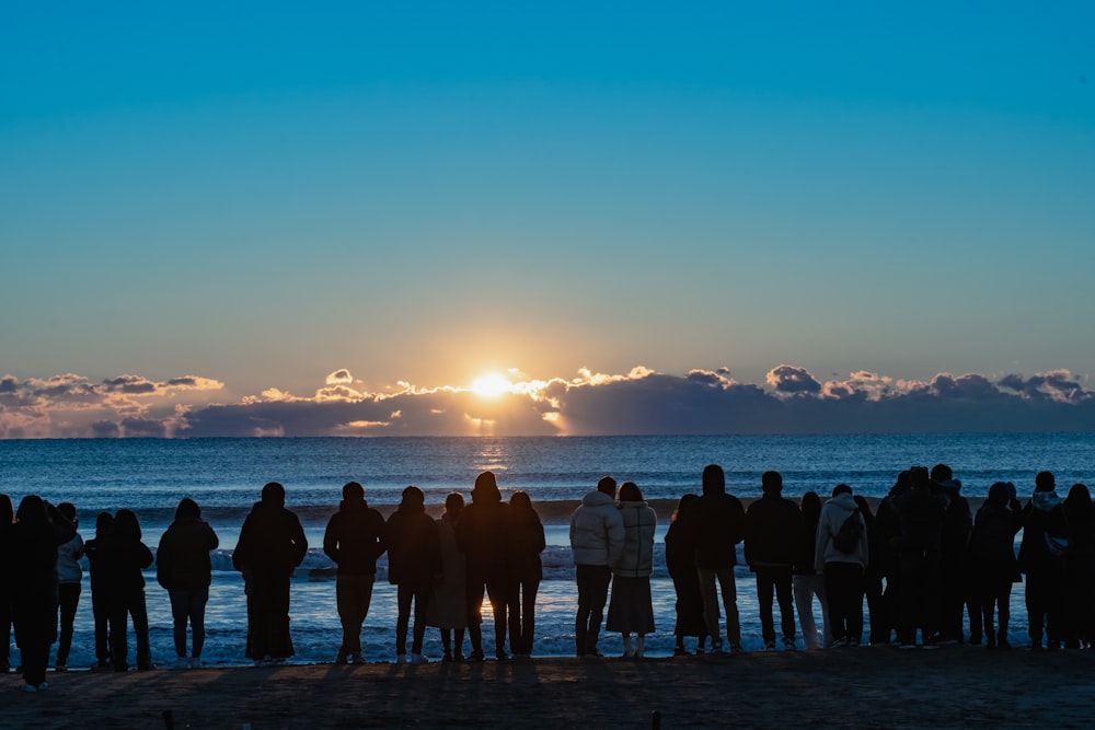 a group of people standing on top of a beach