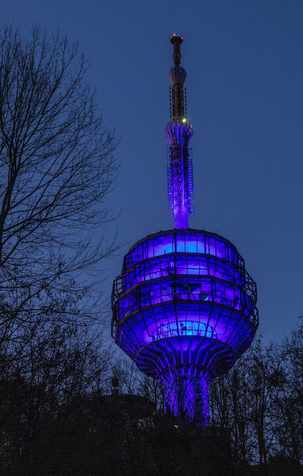 une haute tour surmontée d’une lumière bleue