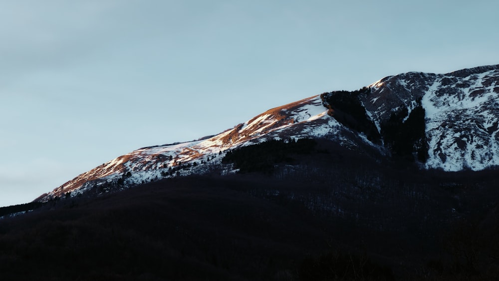 a snow covered mountain with a blue sky in the background