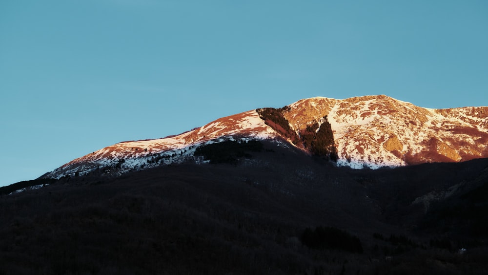 a snow covered mountain with a blue sky in the background