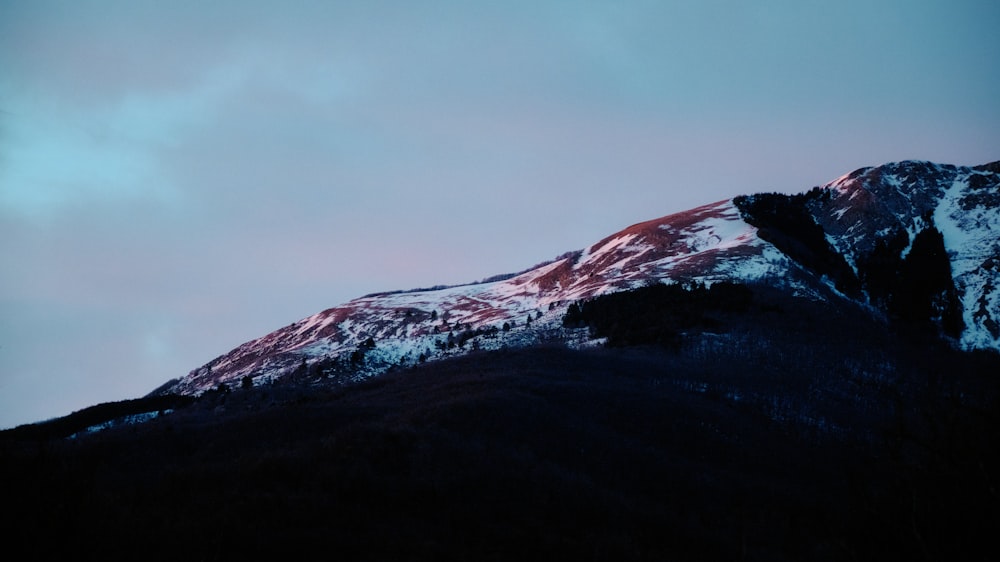 a snow covered mountain with a blue sky in the background