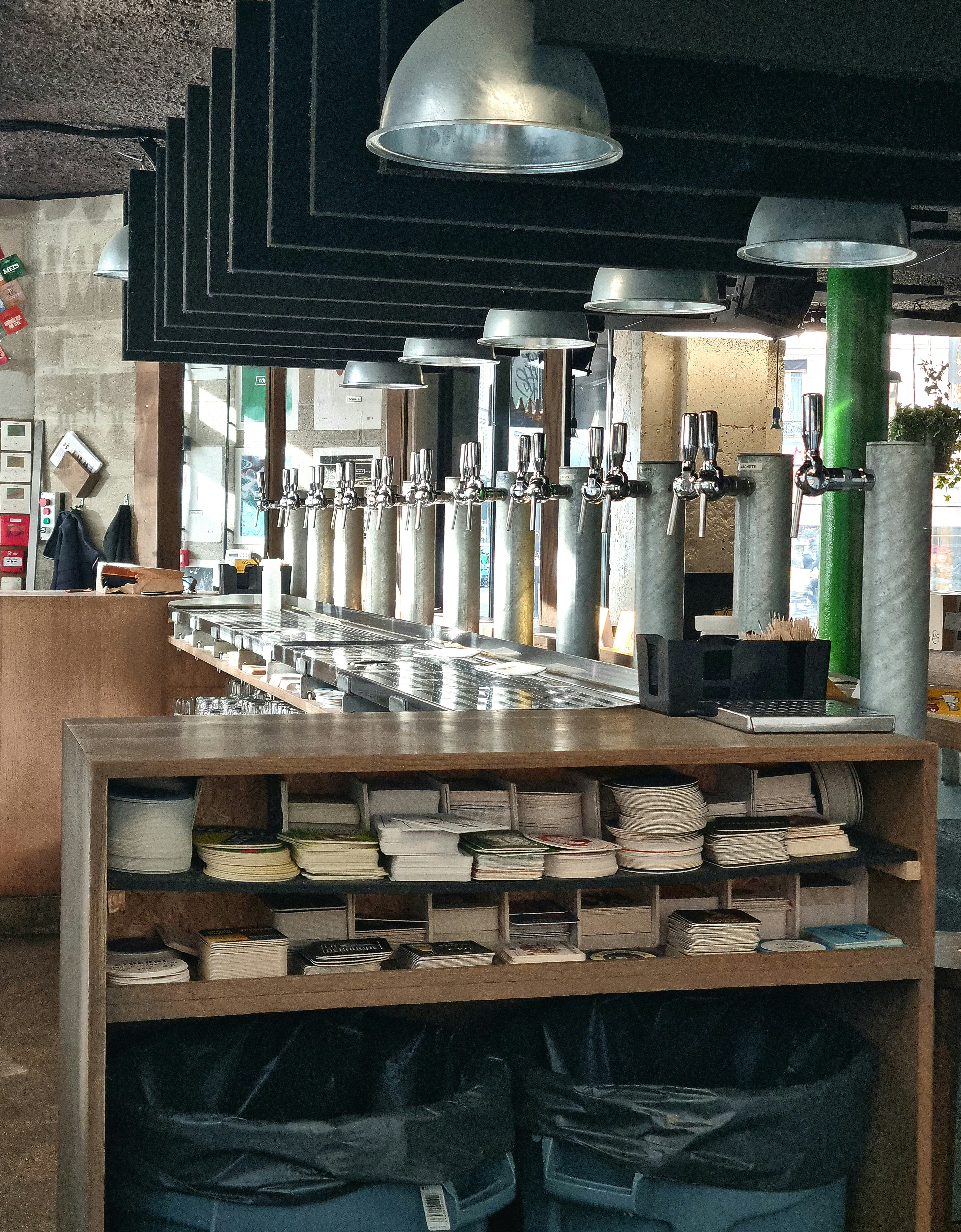 Metal beer taps lined up along an industrial bar counter.